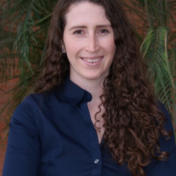 Julia Davis, ACE, Vice President of Ponaman Healthcare Consulting, smiling in a professional setting with greenery in the background.